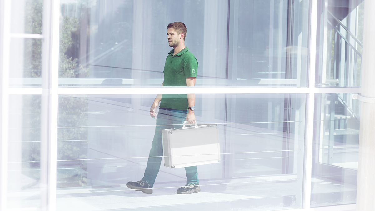 Person geht mit einem Koffer durch ein Gebäude