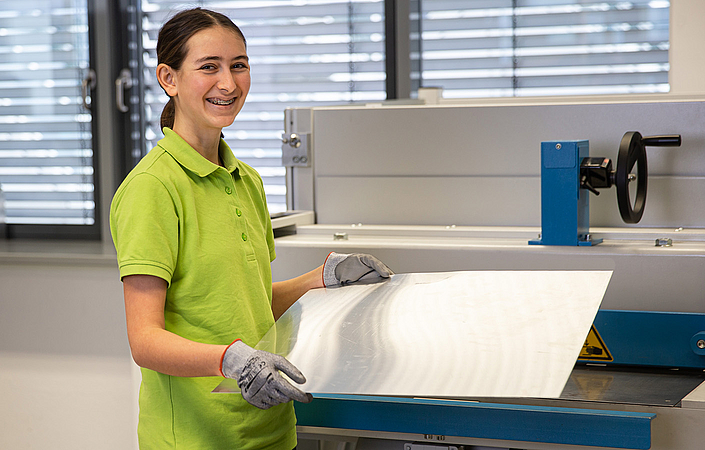 Mechatroniker-Azubine arbeitet an der Schneidemaschine